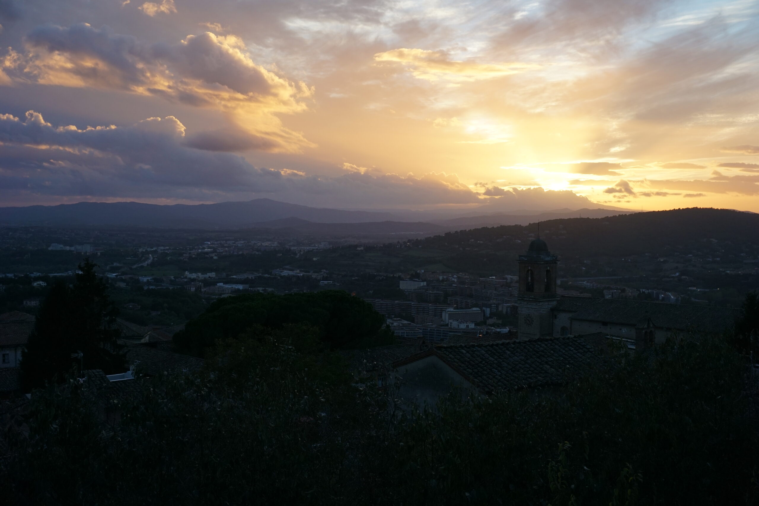 A view of a sunset over some hills in the distance