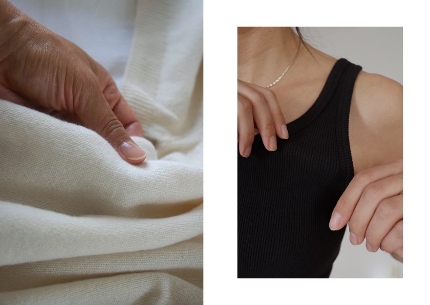 Close-up of a hand holding soft white cashmere fabric, showcasing its texture.