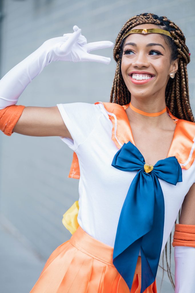 Black Woman dressed up as Sailor Venus | Halloween and Cosplay Ideas for women with Blonde Box Braids.