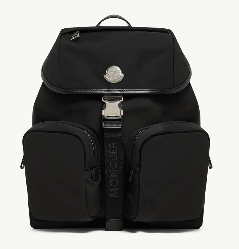 A sleek black Moncler backpack featuring a top flap, front zippered pockets, and a branded strap.